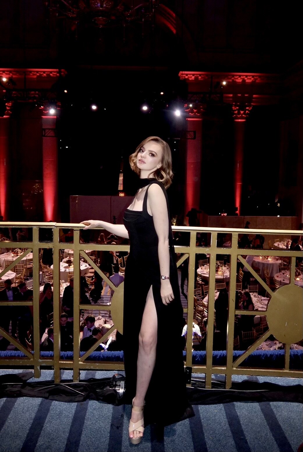 Madison Campbell wearing a black evening gown beside a balcony