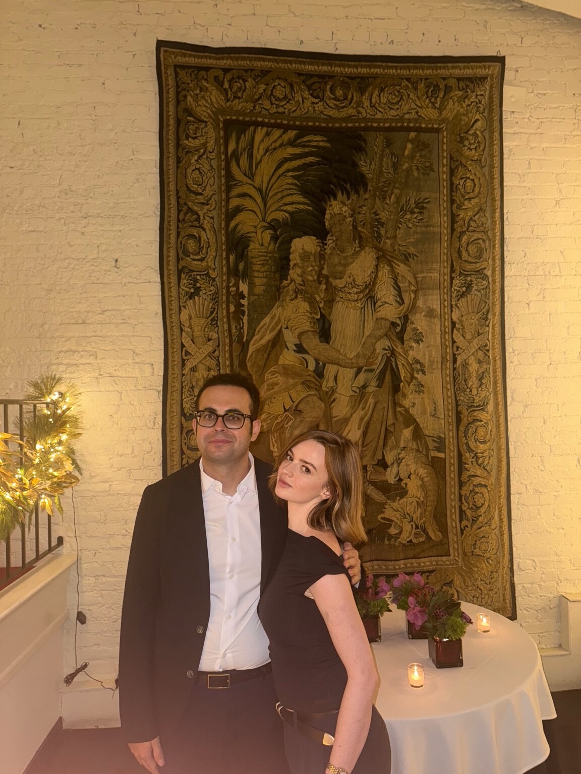 Madison Campbell wearing a black dress with a guest at a candlelit event