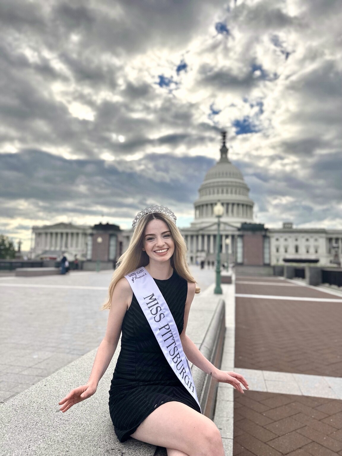 Madison Campbell seated outside the U.S. Capitol wearing her Miss Pittsburgh sash