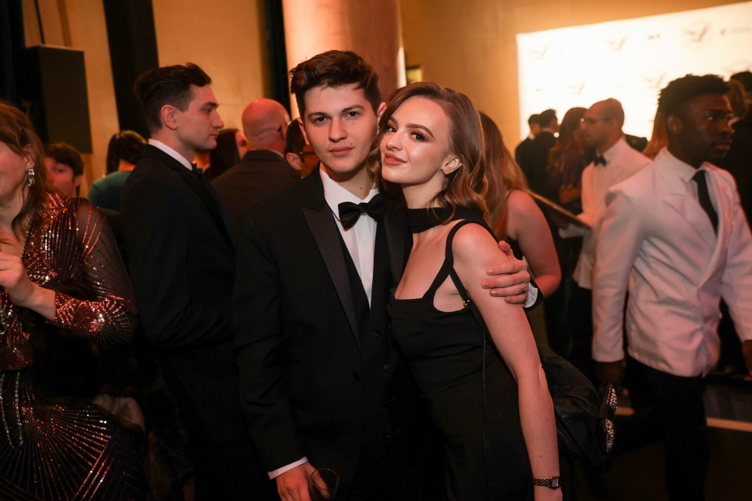 Madison Campbell wearing a black dress with a guest at a formal event